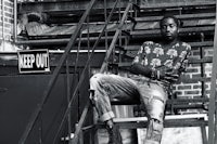 a black and white photo of a man sitting on stairs