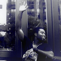 a man waving his hand in front of a window